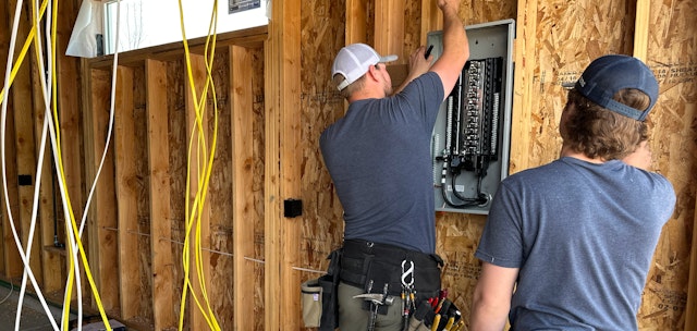 Electricians working on panel.